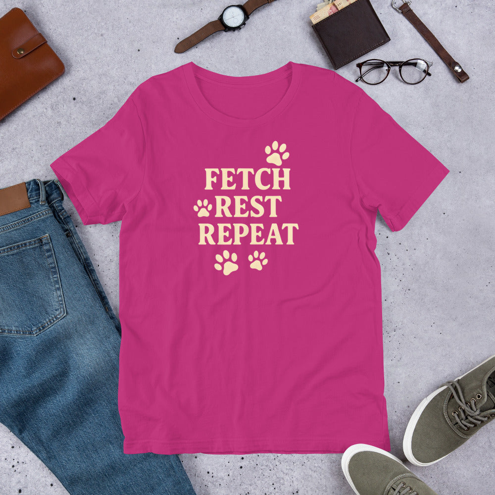 "Fetch Rest Repeat" - Fun Labrador T-Shirt Pink t-shirt with 'FETCH REST REPEAT' text on a gray surface with casual items.