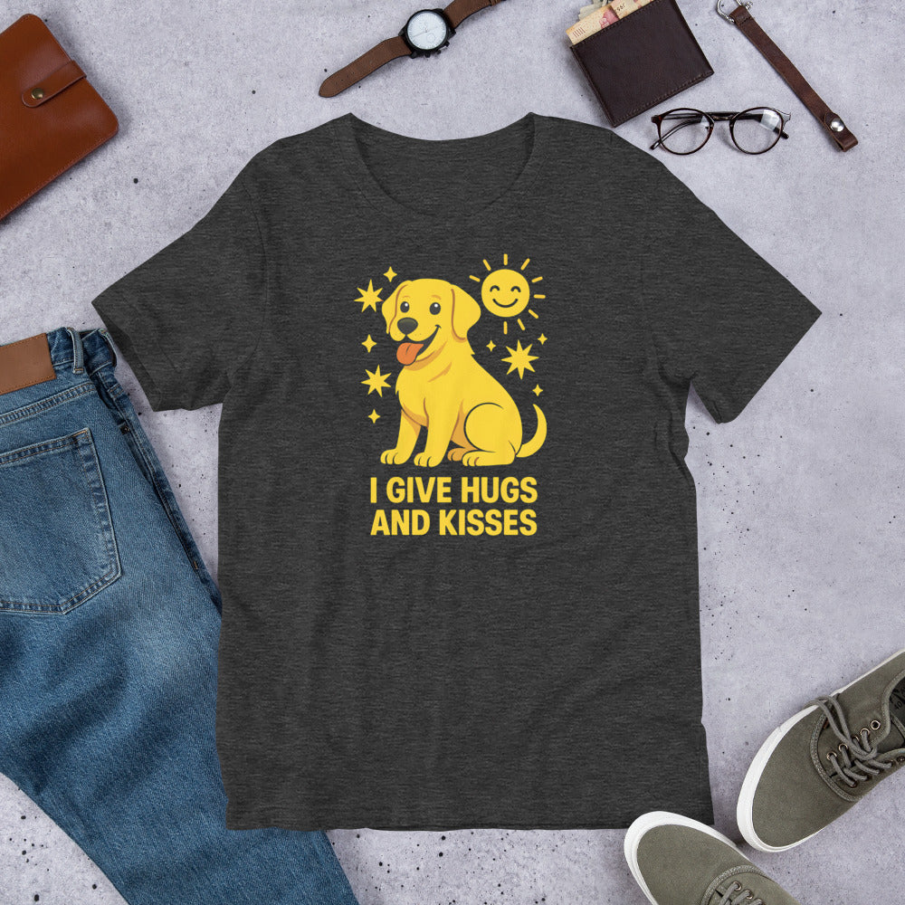 "I Give Hugs And Kisses " – Fun Labrador T-Shirt Dark gray t-shirt with a yellow dog graphic and text 'I give hugs and kisses' on a concrete surface with jeans, shoes, and accessories.