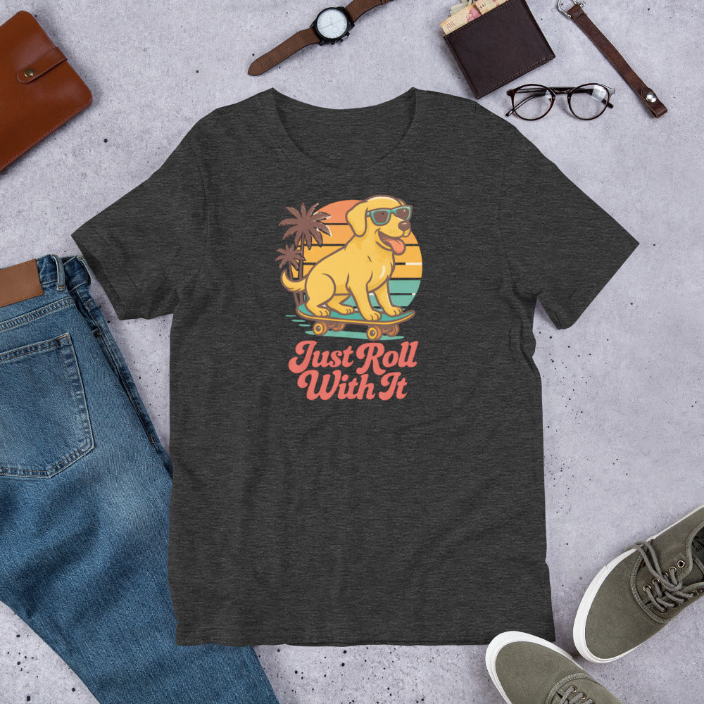 "Just Roll With It " - Yellow Lab – Fun Labrador T-Shirt Dark gray t-shirt with a graphic of a dog on roller skates and 'Just Roll With It' text, surrounded by jeans, shoes, and accessories.