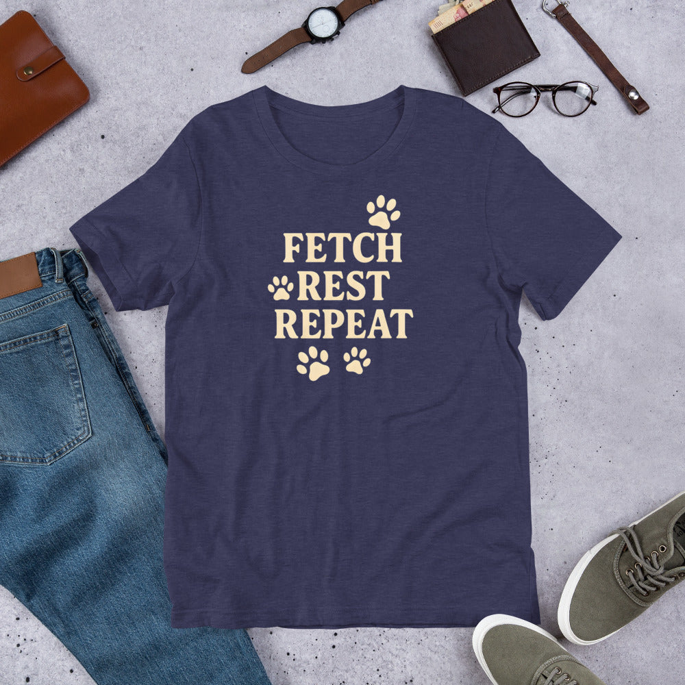 "Fetch Rest Repeat" - Fun Labrador T-Shirt Navy blue t-shirt with 'Fetch Rest Repeat' text on a concrete surface with casual items.