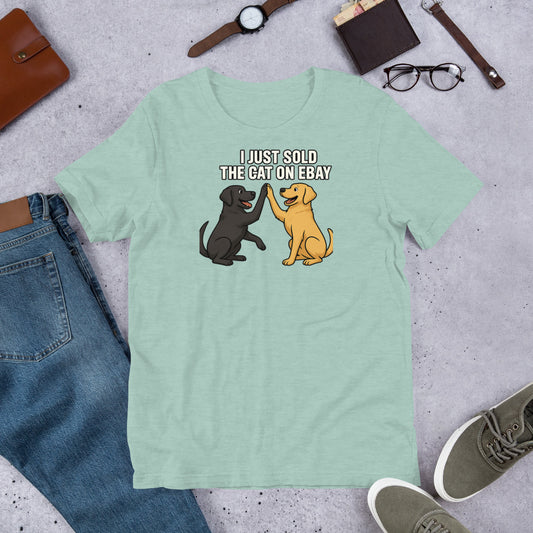 "I Just Sold The Cat On eBay" - Fun Labrador T-Shirt Light green t-shirt with cartoon dogs and text on a gray surface with jeans, shoes, and accessories.