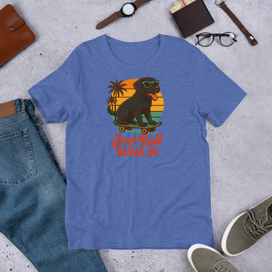 "Just Roll With It" - Black Labrador – Fun Labrador T-Shirt Blue t-shirt with a graphic of a dog on a skateboard and text 'Just Roll With It' displayed on a concrete surface with casual items.