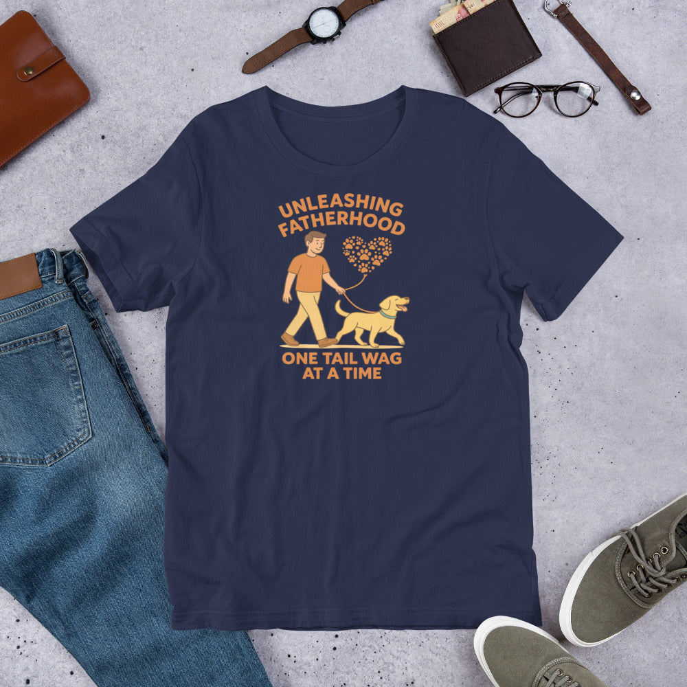 "Unleashing Fatherhood " – Fun Labrador T-Shirt Navy blue t-shirt with a graphic and text 'Unleashing Fatherhood, One Tail Wag at a Time' on a concrete surface with jeans and shoes.