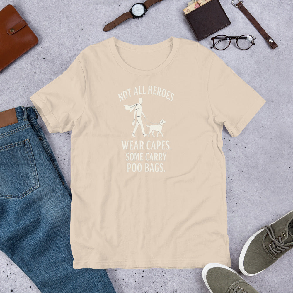 "Not All Heroes Wear Capes" - Fun Labrador T-Shirt Beige t-shirt with a printed message on a gray surface with jeans, shoes, and accessories.