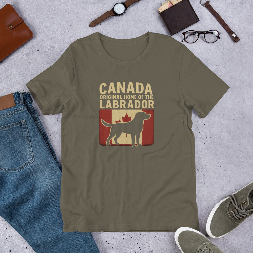 Canada – Original Home of the Labrador - Fun Labrador Tee Green t-shirt with Labrador Retriever graphic and text on a concrete surface with jeans, shoes, and accessories.