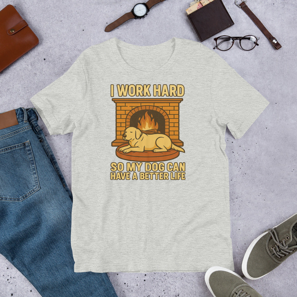 "I Work Hard So My Dog Can Have A Better Life " - Fun Labrador T-Shirt Gray t-shirt with a graphic of a dog by a fireplace and text 'I work hard so my dog can have a better life' on a concrete surface with jeans, shoes, and a bag.