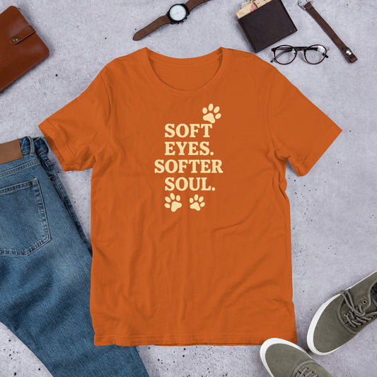 "Soft Eyes Softer Soul" - Fun Labrador T-Shirt Orange t-shirt with 'Soft Eyes. Softer Soul.' text on a concrete surface with jeans, shoes, and accessories.