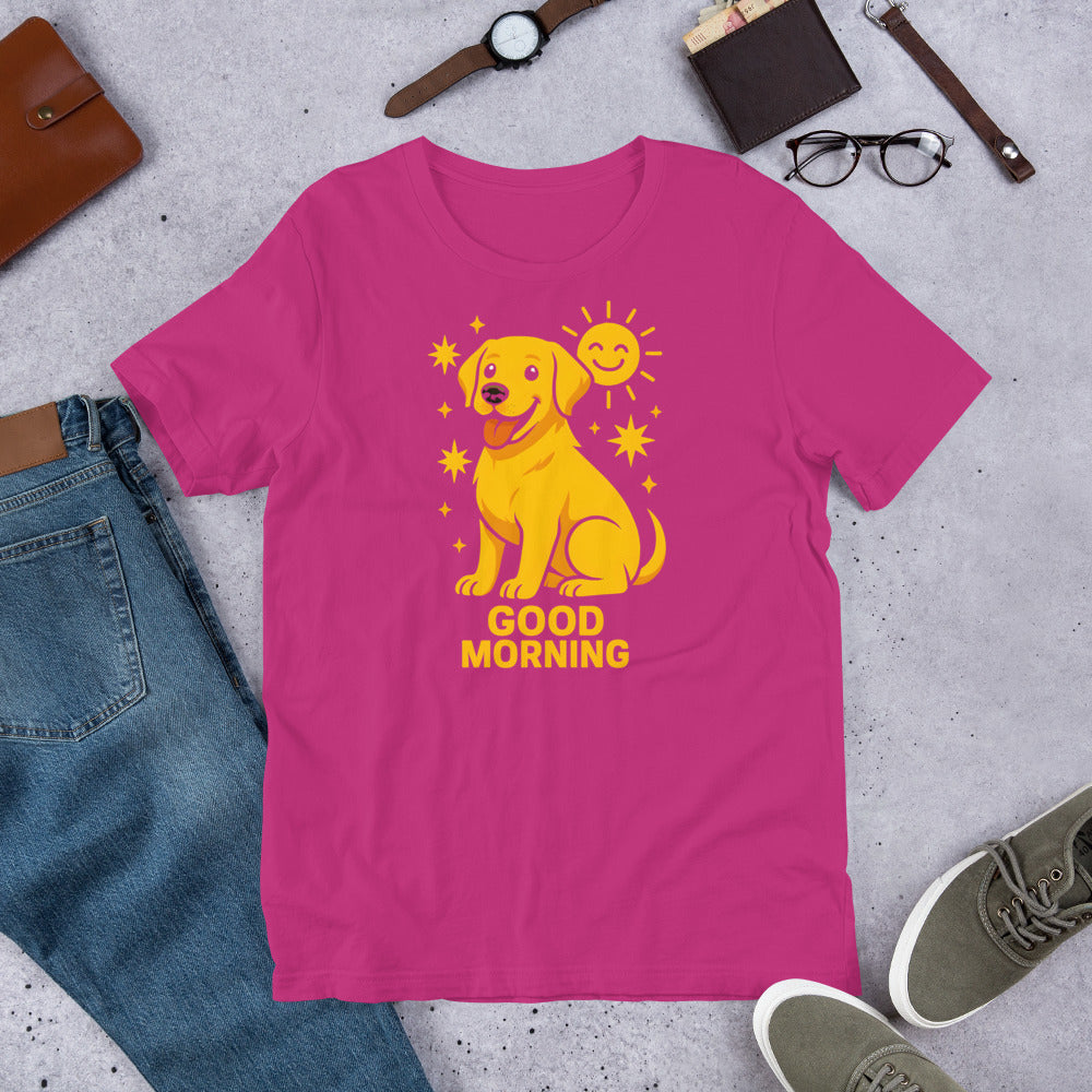 "Good Morning " – Fun Labrador T-Shirt Pink t-shirt with yellow dog graphic and 'Good Morning' text on a gray surface with casual items.