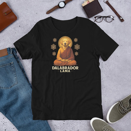 "Dalabrador Lama " – Fun Labrador T-Shirt Black t-shirt with a dog in monk robes graphic and 'DALABRADOR LAMA' text, surrounded by jeans, shoes, and accessories on a concrete surface.