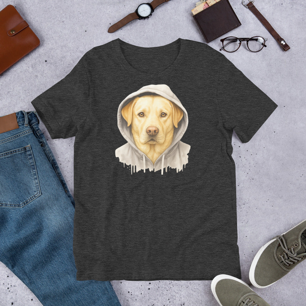 "Yellow Labrador In A Hoodie " – Fun Labrador T-Shirt Dark gray t-shirt with a dog wearing a hoodie graphic, surrounded by jeans, shoes, and accessories on a concrete surface.