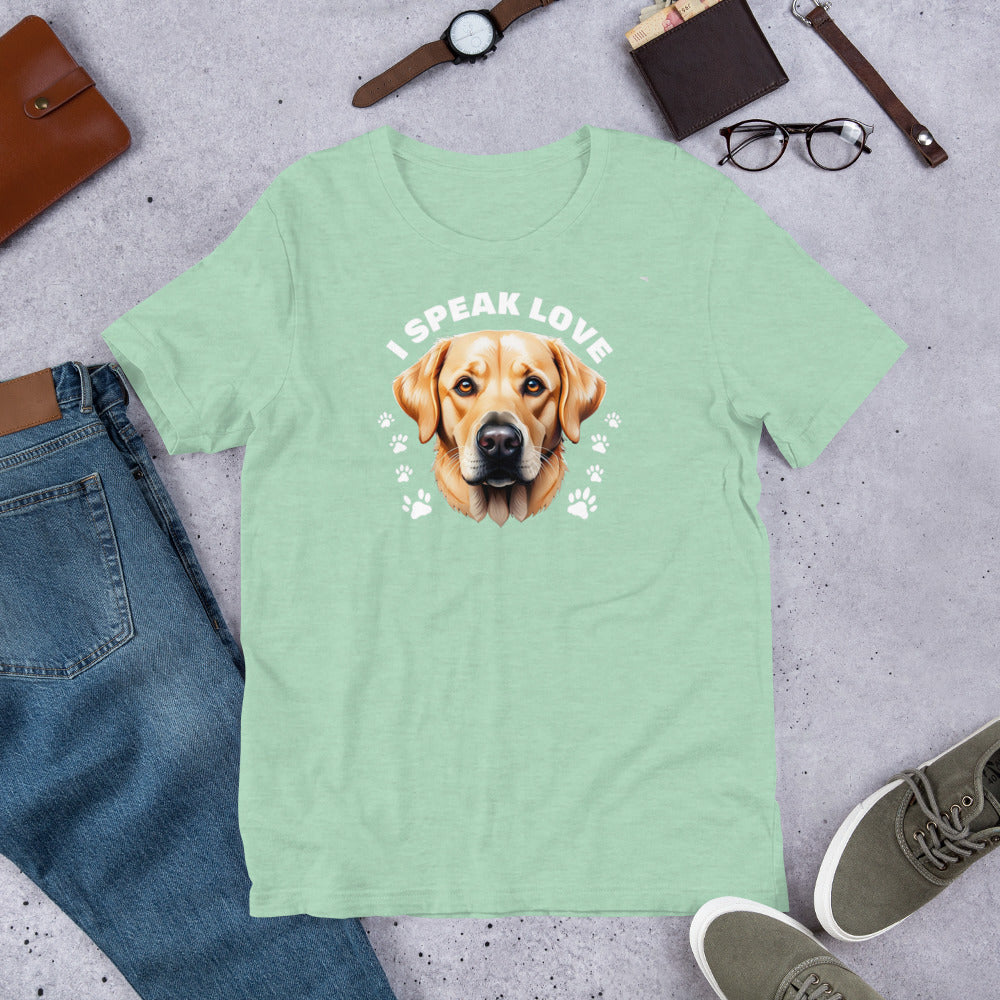 "I Speak Love" - Fun Labrador T-Shirt Green t-shirt with a dog graphic and 'I Speak Love' text, surrounded by jeans, shoes, and accessories on a concrete surface.