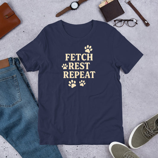 "Fetch Rest Repeat" - Fun Labrador T-Shirt Navy blue t-shirt with 'FETCH REST REPEAT' text on a concrete surface with casual items.