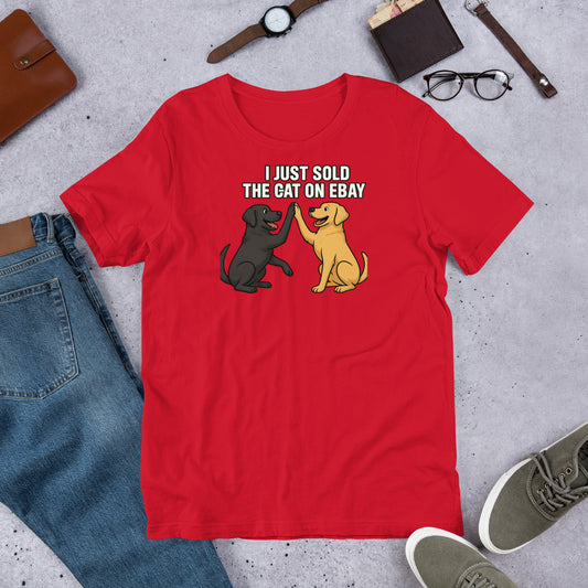 "I Just Sold The Cat On eBay" - Fun Labrador T-Shirt Red t-shirt with dog graphic and text on a gray surface with casual items.