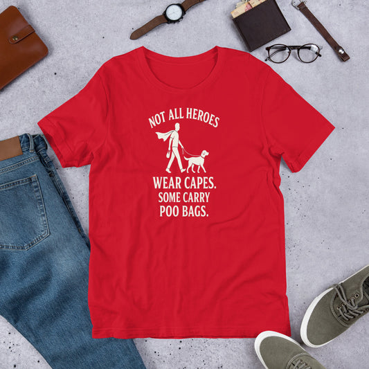 "Not All Heroes Wear Capes" - Fun Labrador T-Shirt Red t-shirt with humorous graphic and text on a gray surface with casual items.