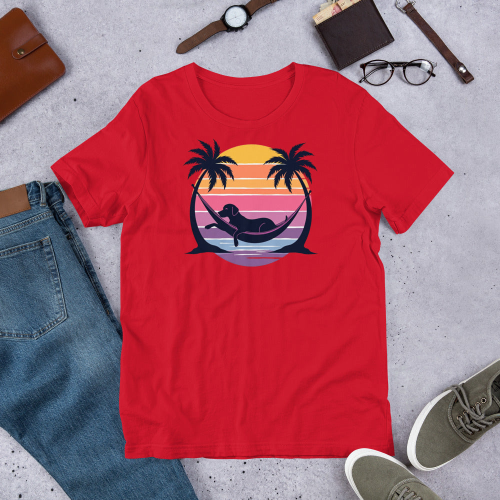 "Labrador In Paradise " – Fun Labrador T-Shirt Red t-shirt with a graphic design of a mermaid in a hammock, palm trees, and a sunset on a concrete surface with jeans, shoes, and accessories.