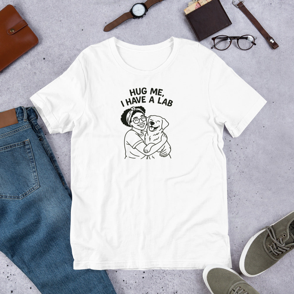 " Hug Me I Have A Lab" - Fun Labrador T-Shirt White t-shirt with a graphic and text 'Hug me, I have a Lab' on a gray surface with jeans and shoes.
