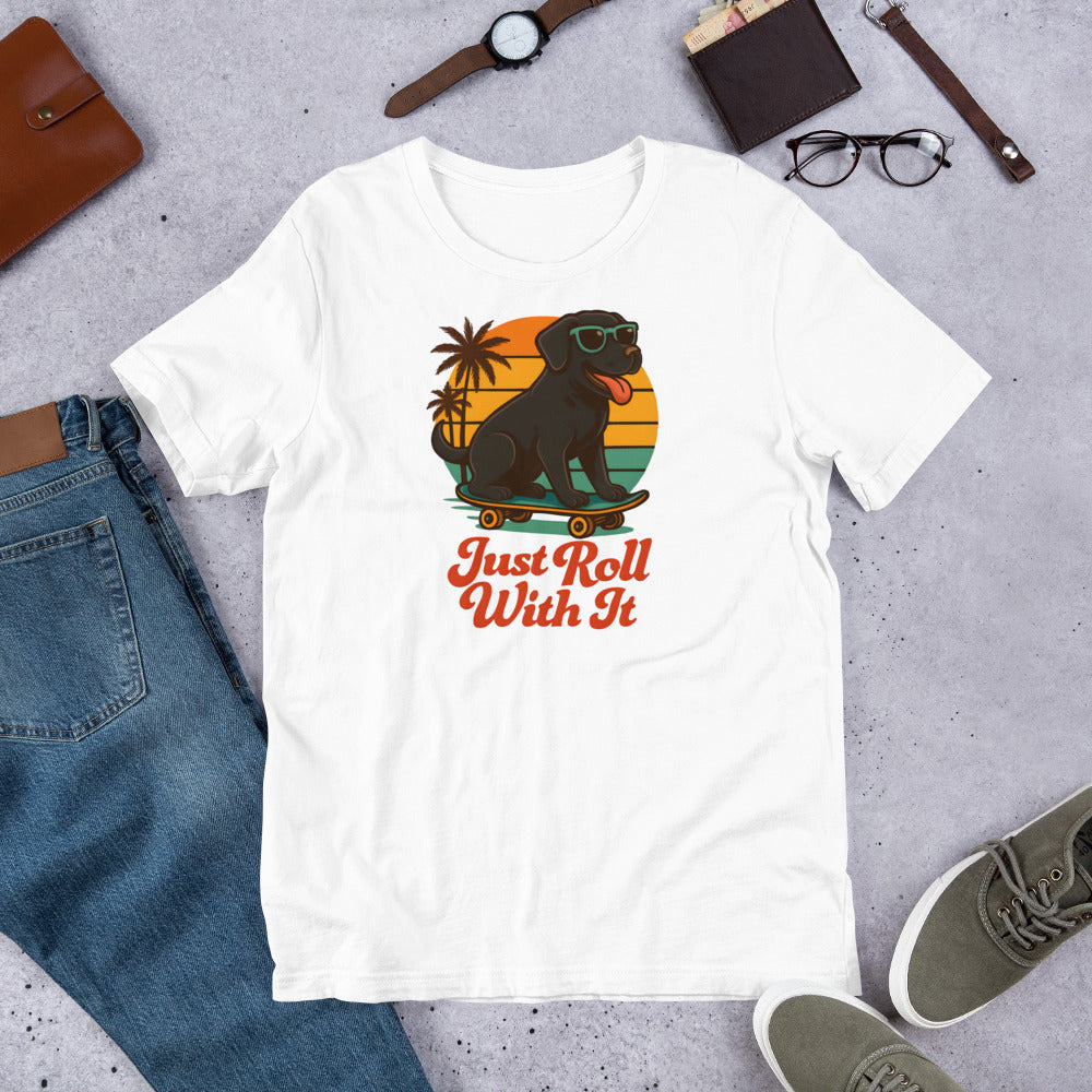 "Just Roll With It" - Black Labrador – Fun Labrador T-Shirt White t-shirt with a dog graphic and 'Just Roll With It' text on a gray surface with jeans, shoes, and accessories.