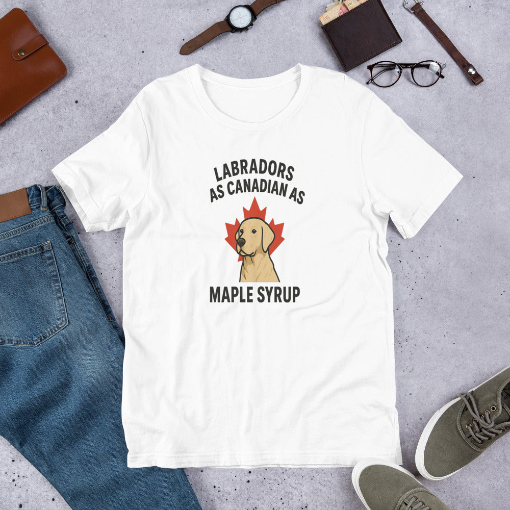 Labradors – As Canadian as Maple Syrup - Fun Labrador Tee White t-shirt with Labrador and maple syrup graphic on a gray surface with jeans, shoes, and accessories.
