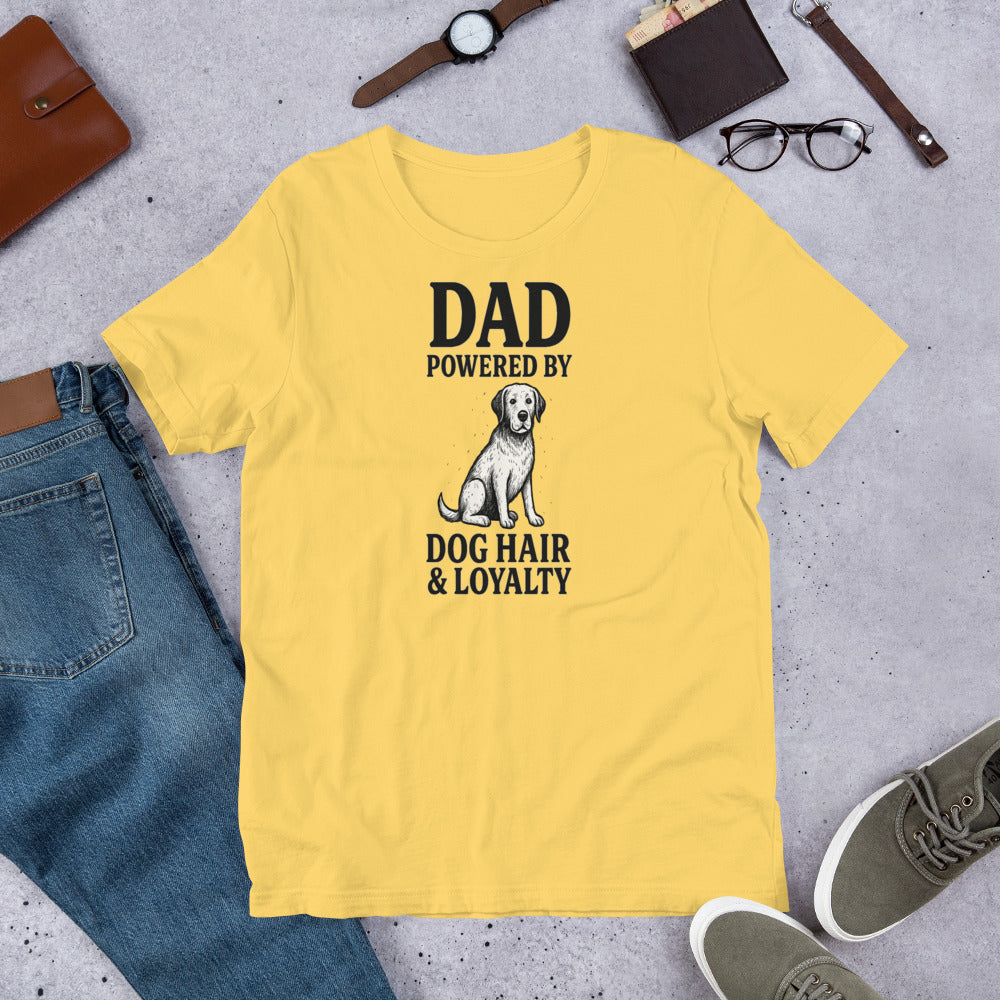"Dad Powered by Dog Hair & Loyalty" – Fun Labrador T-Shirt. Yellow t-shirt with 'Dad powered by dog hair & loyalty' text and a dog graphic on a concrete surface with jeans, shoes, and accessories. 